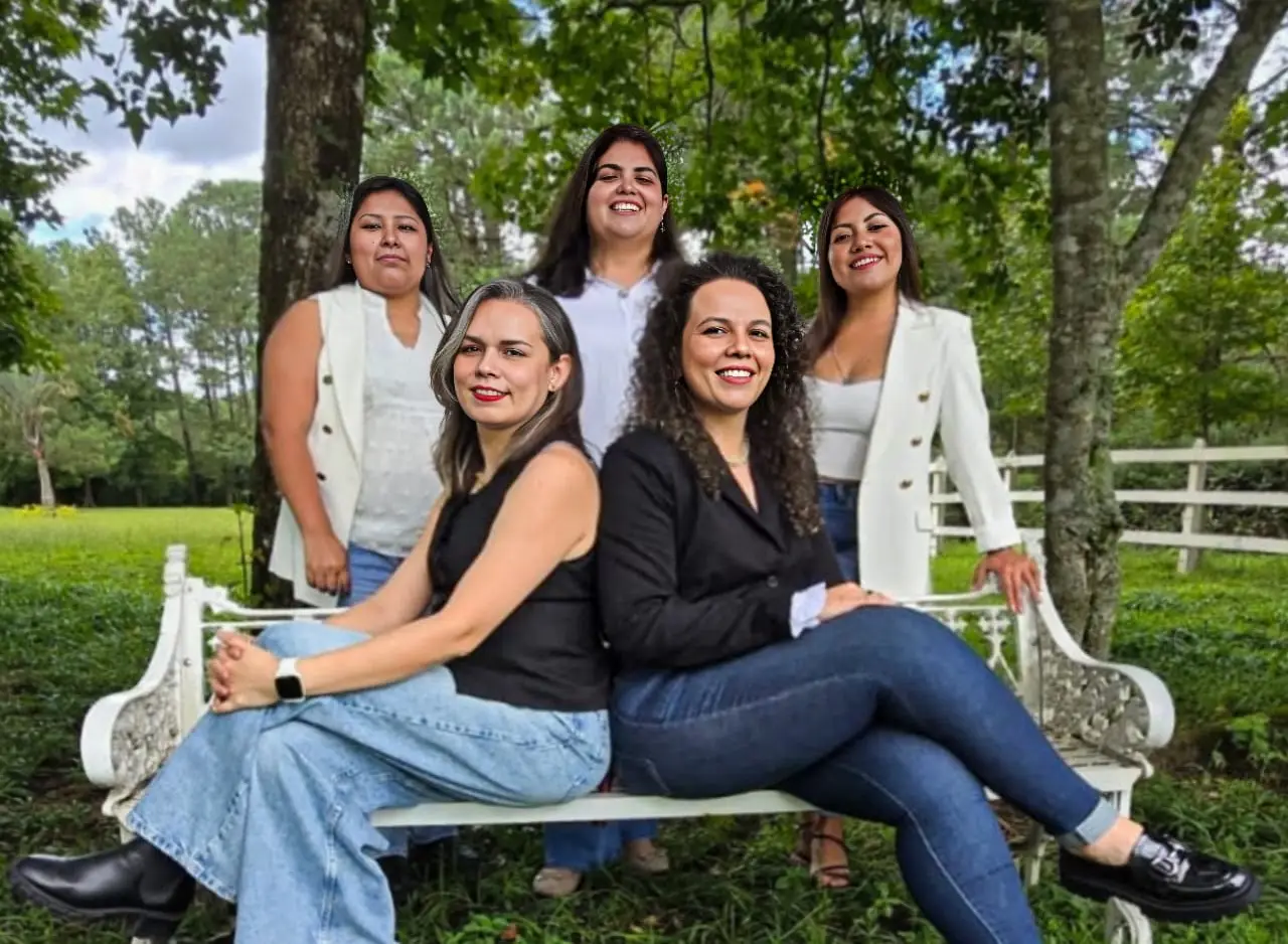 Equipo de MAS Trámites sentado en una banca en un jardín