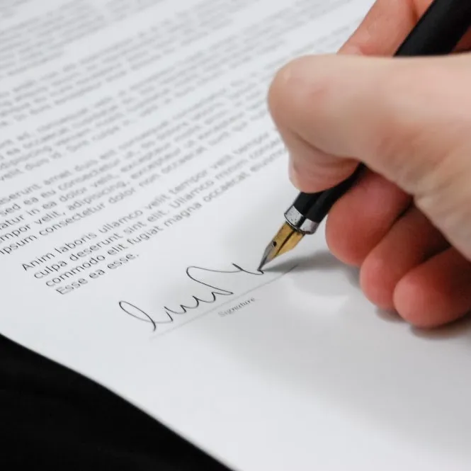 Persona firmando un documento con pluma fuente