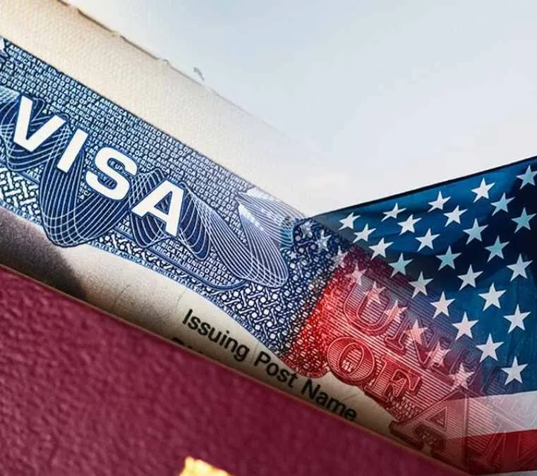 Visa de Estados Unidos impresa en un pasaporte junto a la bandera estadounidense